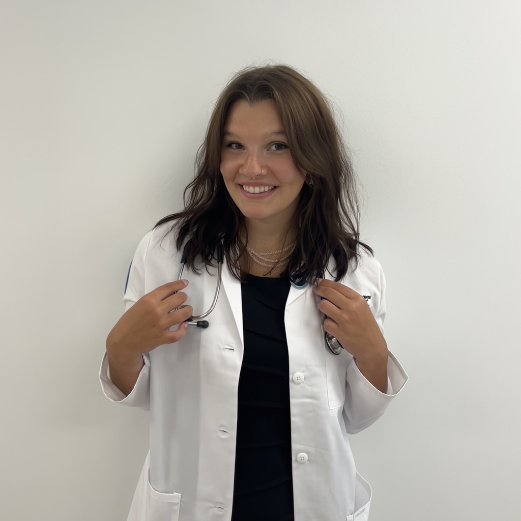 woman with long brown hair and a white coat