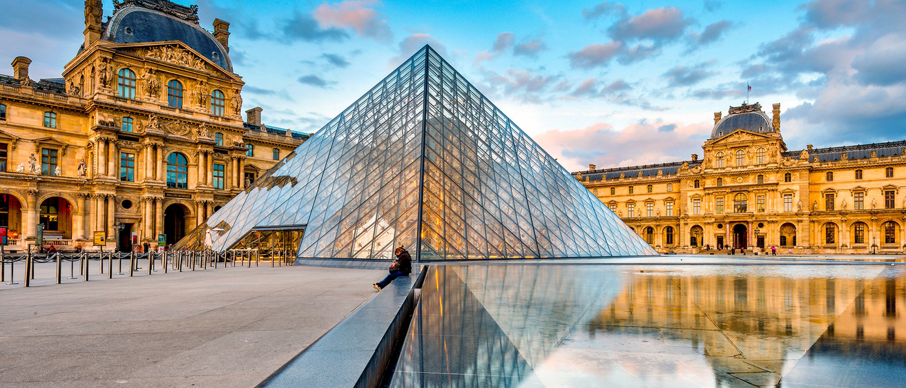 The glass pyramid and exterior of the Louvre Museum in Paris, France.