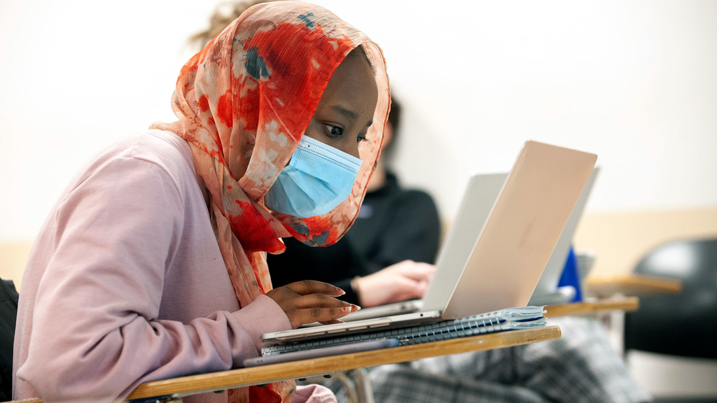 A young female student studying the Arabic language on her laptop.